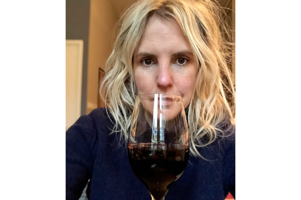 A picture of your hero, Ardra, looking dead-eyed with a massive glass of red wine. Her hair tho, looks awesome.